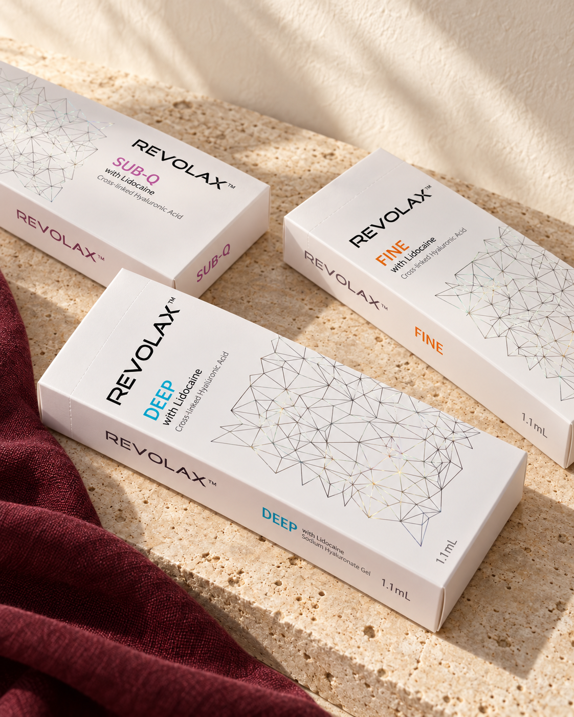 Styled REVOLAX packaging on cream stone with burgundy fabric